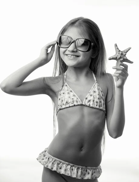 Black and white portrait of girl in swimsuit holding starfish — Stock Photo, Image