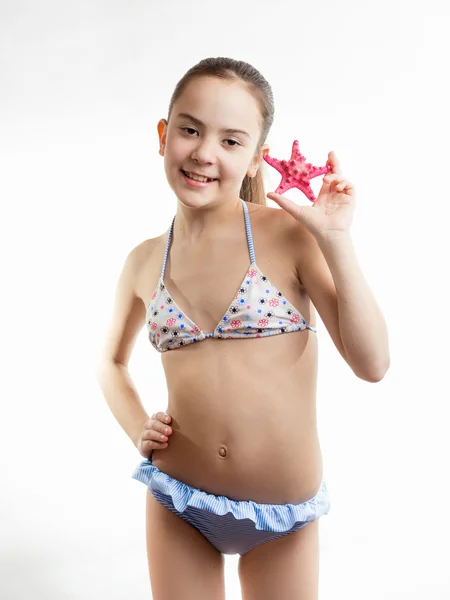 Felice ragazza in costume da bagno mostrando stelle marine rosse — Foto Stock