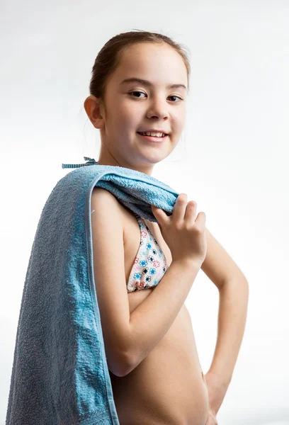 Roztomilá usmívající se dívka pózuje s modrým ručníkem nad bílým pozadím — Stock fotografie