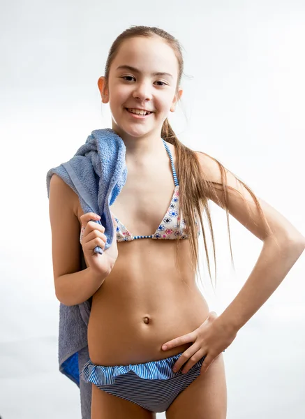 Menina feliz em maiô posando com toalha de praia azul — Fotografia de Stock