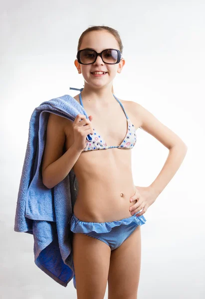 Menina sorridente feliz em óculos de sol segurando toalha de praia — Fotografia de Stock