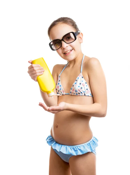 Retrato de menina feliz aplicando loção bronzeado do sol — Fotografia de Stock