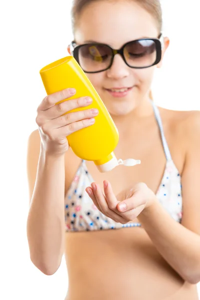 Isolated portrait of cute girl applying sunscreen — Stock Photo, Image