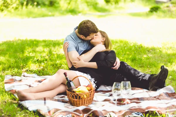 Paar zoenen op deken in park op zonnige dag — Stockfoto