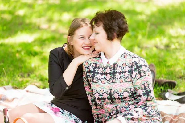 Tersenyum anak perempuan dewasa dan ibu duduk di selimut di taman — Stok Foto