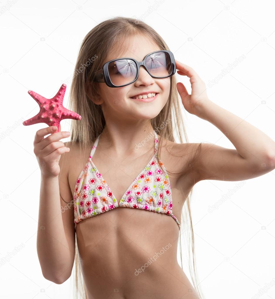 portrait of smiling girl in sunglasses posing with starfish