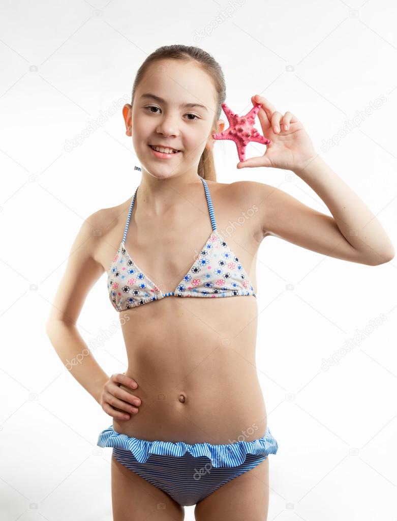 smiling girl in swimsuit holding red starfish