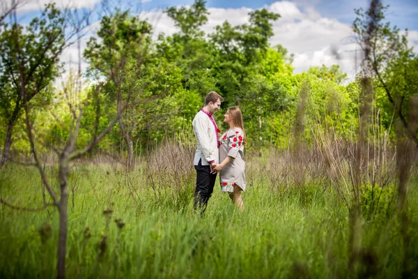 Ukrainisches Paar hält Händchen auf dem Feld und schaut einander an — Stockfoto