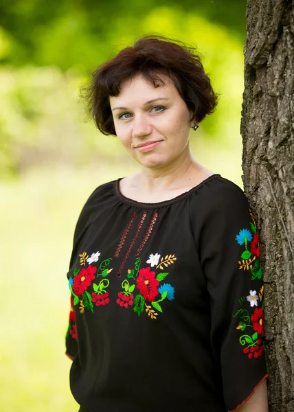 Middle aged woman in traditional ukrainian shirt posing at meado — Stock Photo, Image