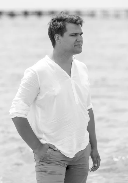 Черно-белый портрет красивого мужчины, позирующего на пляже — стоковое фото