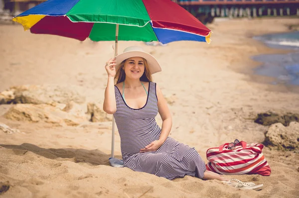 Toned foto de mulher grávida bonito em vestido listrado na praia — Fotografia de Stock