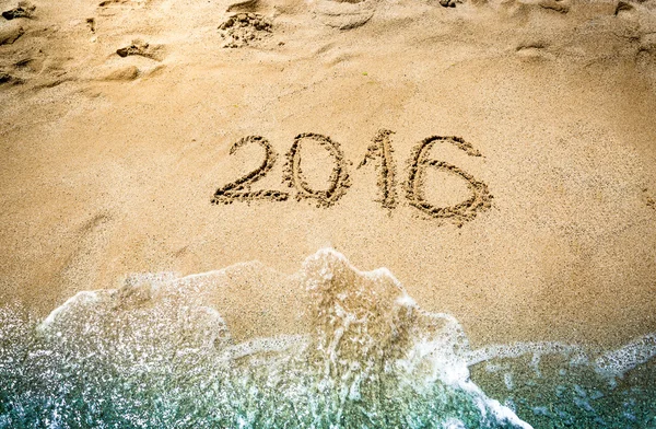 Närbild av 2016 siffror skrivs på våt sand på stranden — Stockfoto