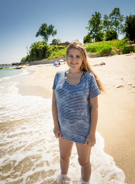 Vrouw in sailor shirt wandelen aan de kust op zonnige dag — Stockfoto