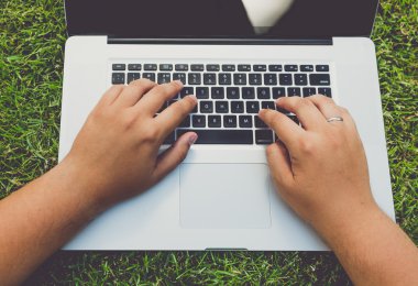 adam çim üzerinde yalan ve dizüstü bilgisayar kullanarak tonda atış