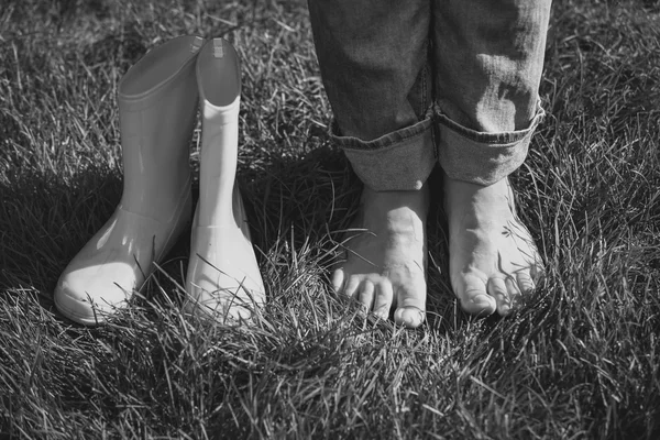 Preto e branco tiro da menina tirou as botas e de pé sobre gras — Fotografia de Stock