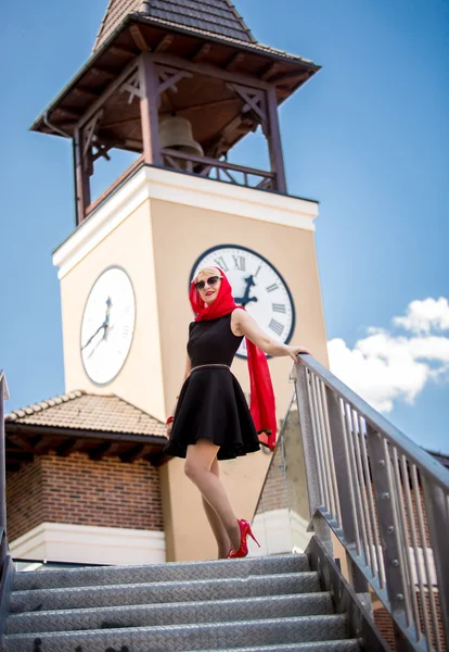 Mulher elegante em vestido preto e cachecol vermelho posando na rua velha — Fotografia de Stock