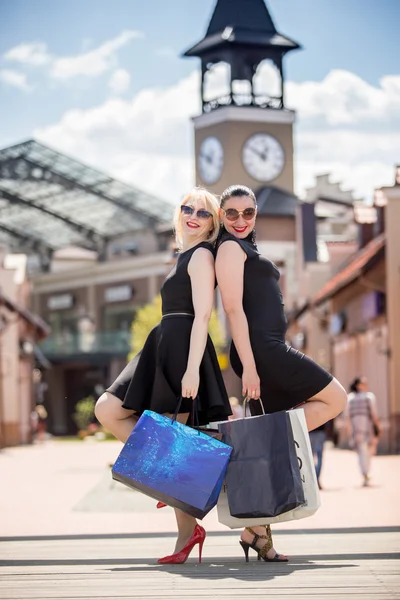 Iki güzel kadın Caddesi'nde alışveriş torbaları ile poz — Stok fotoğraf