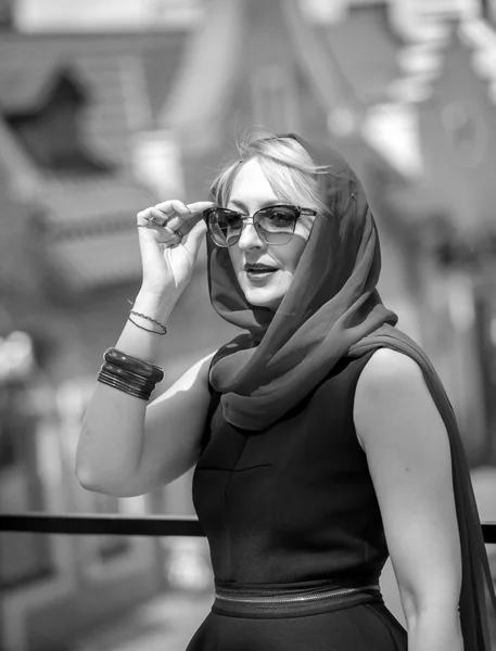 Porträt einer eleganten Frau mit Schal und Brille, die auf der Straße posiert — Stockfoto