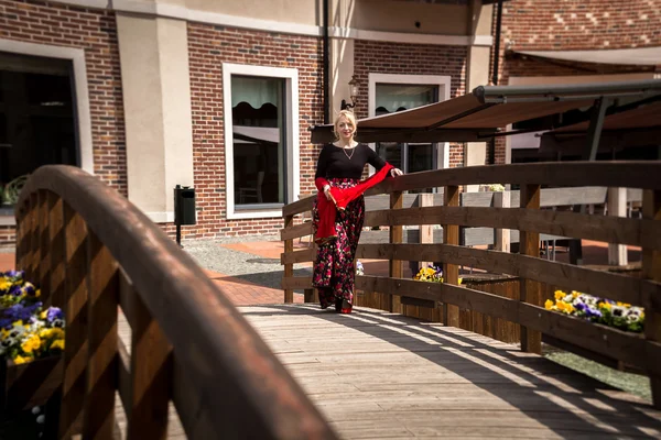 Toned photo of beautiful woman walking over old wooden bridge — Stock Photo, Image