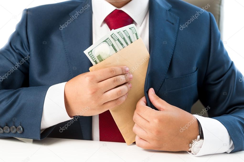 conceptual photo of bribed man putting money in the suit pocket