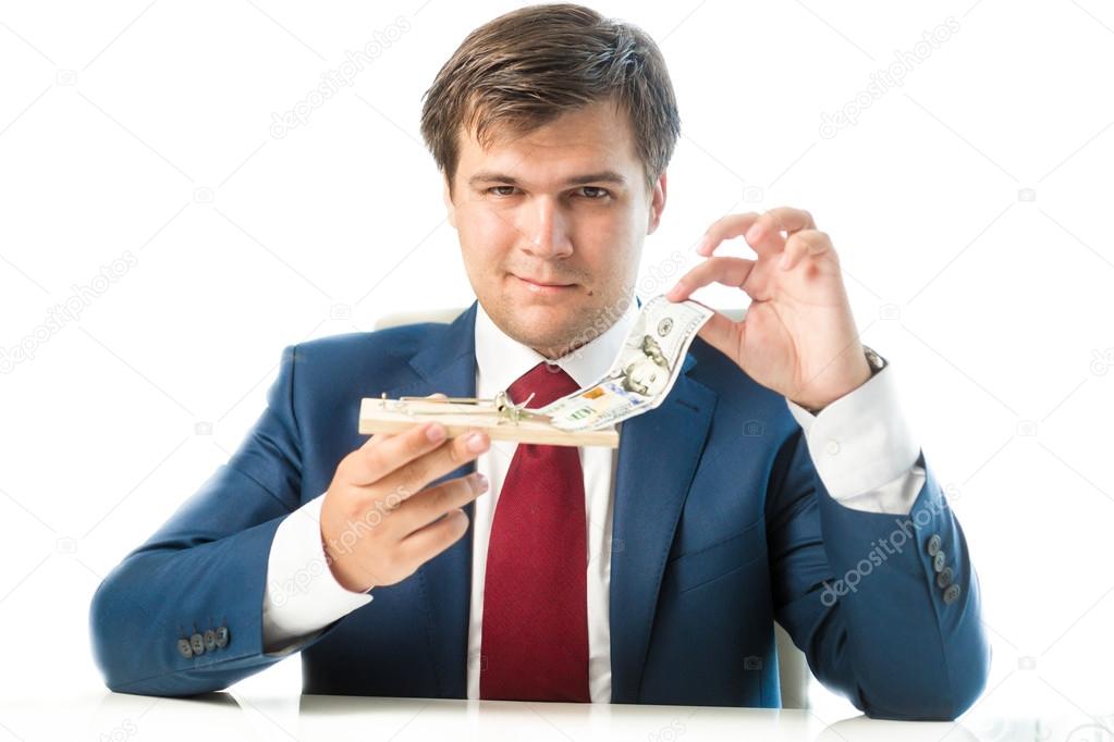 cunning businessman taking dollar bill out of mousetrap