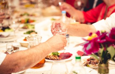 Closeup of two men clinking glasses with vodka at restaurant