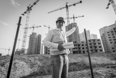 Black and white portrait of architect posing on building site