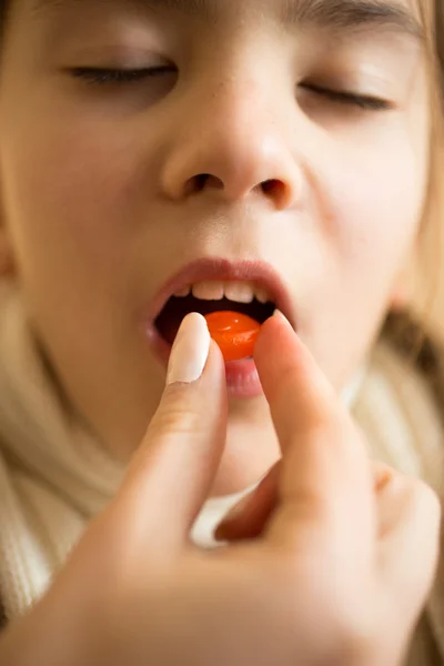 Fechar-se de menina doente colocando pílula na língua — Fotografia de Stock