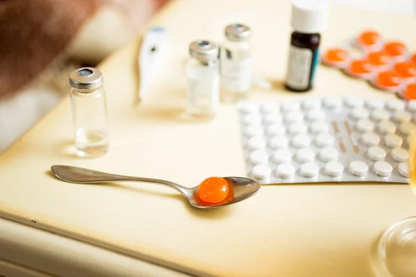 Macro shot of pills in blisters and ampules on bedside table — Stock Photo, Image