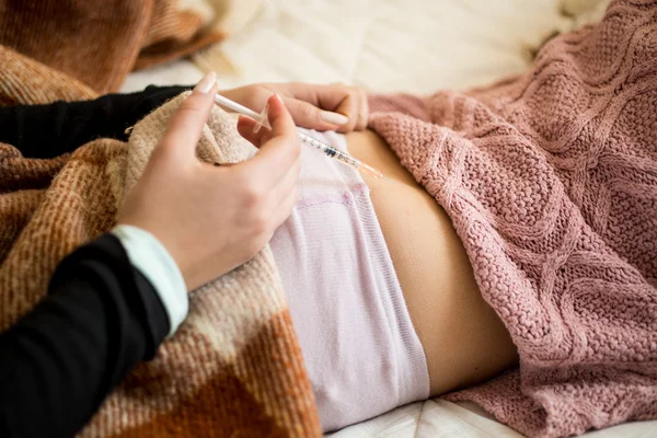 Крупный план женщины, делающей укол в задницу больного ребенка — стоковое фото