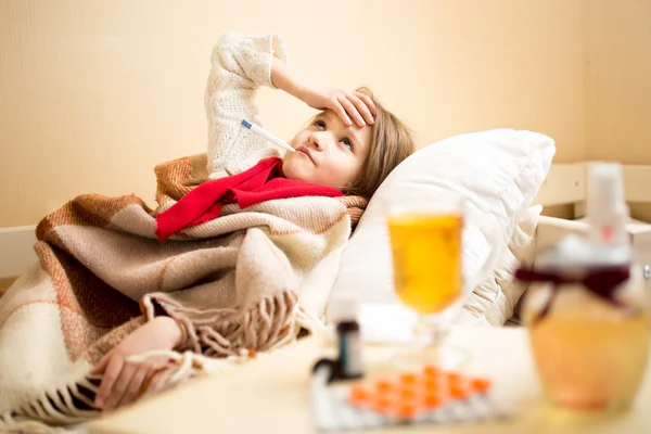 Sick girl with high temperature resting in bed — Stockfoto