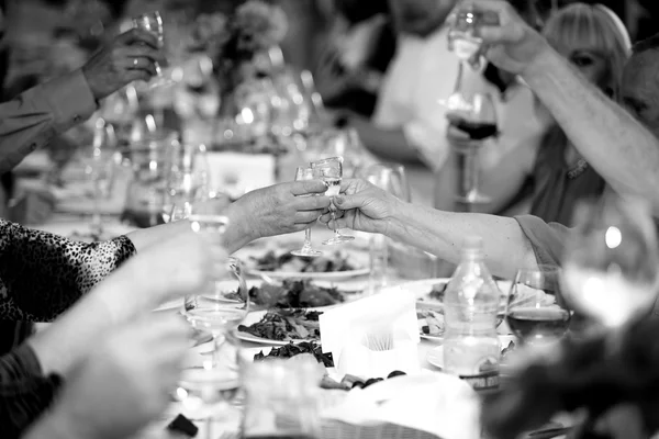 Black and white photo of celebrating people clinking glasses — ストック写真