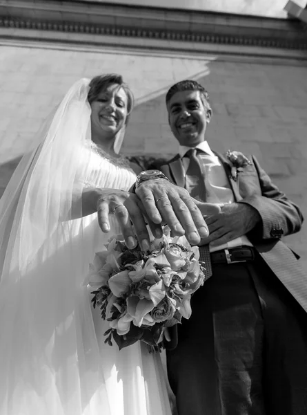 Black and white portrait of newly married couple showing rings — Stock Photo, Image