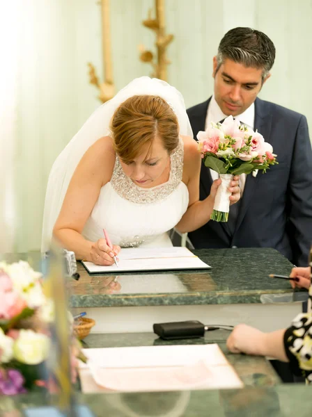 Young bride signing wedding contract at registry office — Stok fotoğraf