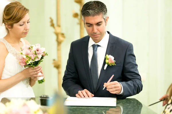 Schöner Bräutigam unterzeichnet Vertrag bei Hochzeitszeremonie — Stockfoto
