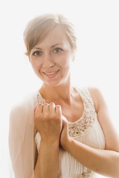Porträt einer schönen lächelnden Braut, die vor einem großen Fenster posiert — Stockfoto