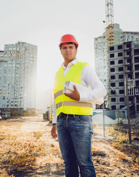 Toned photo of engineer posing against building site at sunset — Stockfoto