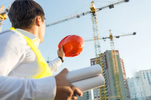 Closeup of engineer posing on building site with orange hardhat — 图库照片