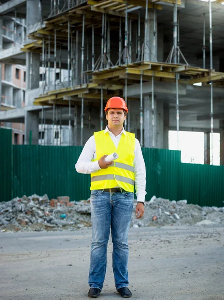Engineer on construction site posing against scaffolding — Stock Photo, Image