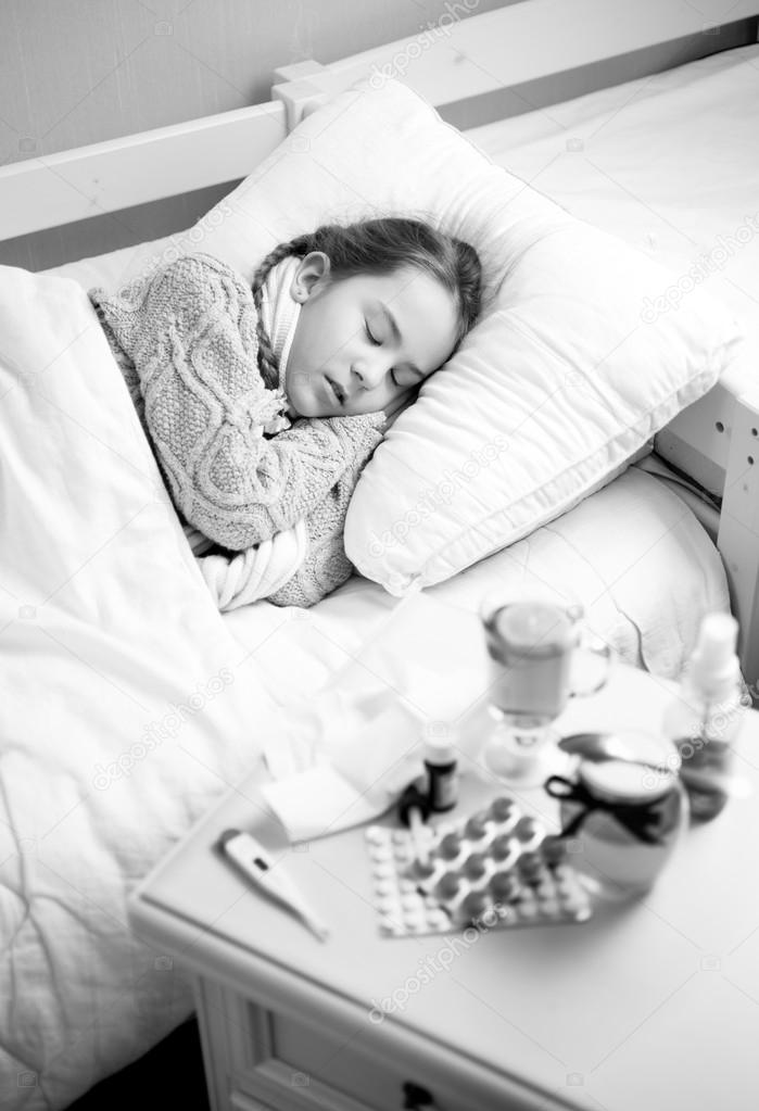 Black and white portrait of sick girl sleeping in bed at home