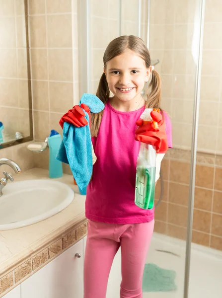 Bonito menina fazendo limpeza no banheiro segurando pano e spray — Fotografia de Stock
