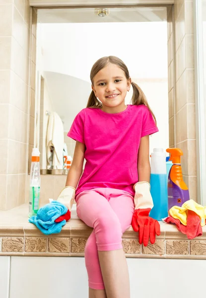 Uśmiechnięta dziewczyna siedząca na zlew w łazience podczas czyszczenia — Zdjęcie stockowe