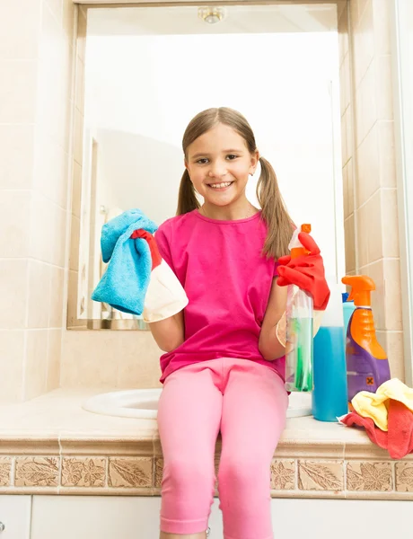 Feliz chica sonriente en guantes de goma posando con trapo en el baño — Foto de Stock