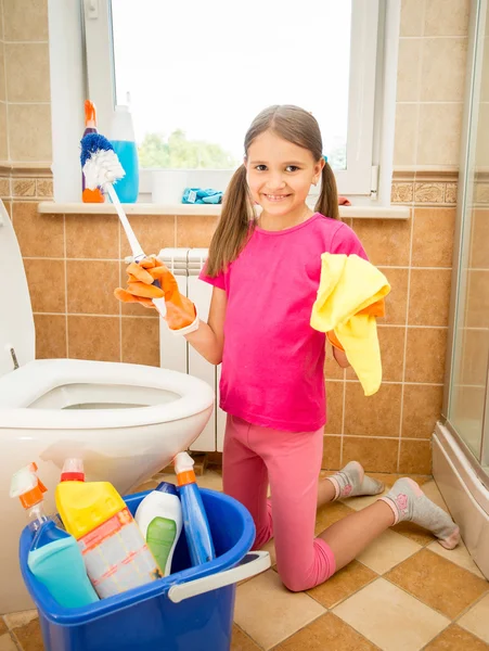 Smiling girl cleaning toilet with brush and rag — Stock Photo, Image