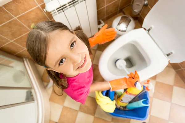 Portrait of cute little girl cleaning toilet with brush — Stock Photo, Image