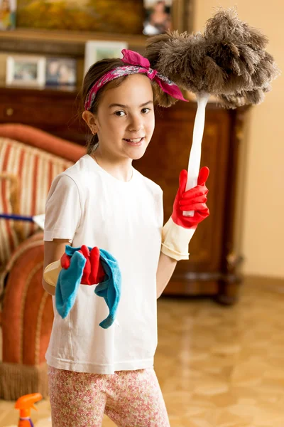 Adolescente chica limpieza sala de estar con paño y cepillo de plumas — Foto de Stock