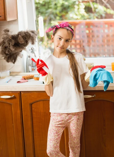 Retrato de niña limpieza desorden en la cocina con paño y cepillo — Foto de Stock