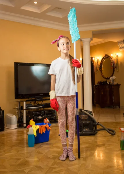 Funny shot of teenager girl cleaning room posing with swab — Stock Photo, Image