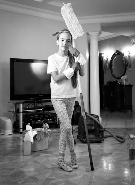 Black and white photo of teenager girl cleaning house with swab — Stock Photo, Image