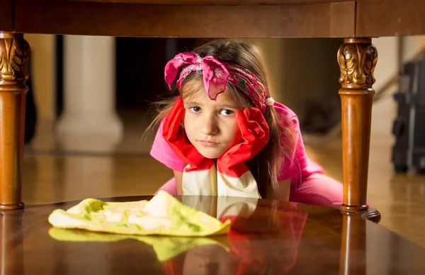 Retrato de cansado menina triste limpeza mesa de madeira — Fotografia de Stock